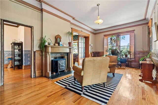 living room featuring crown molding, light wood-type flooring, and a high end fireplace