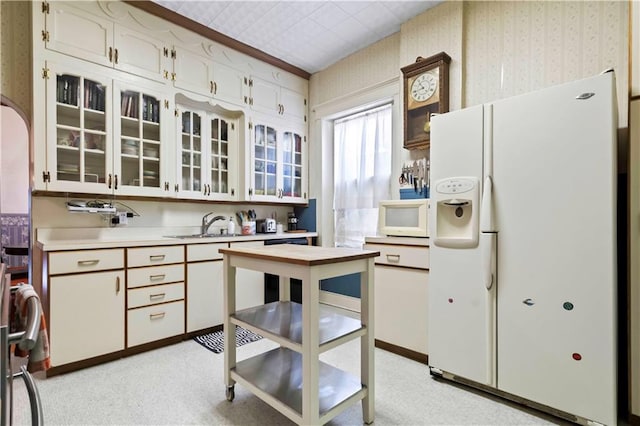 kitchen featuring sink, white cabinets, white appliances, and light colored carpet