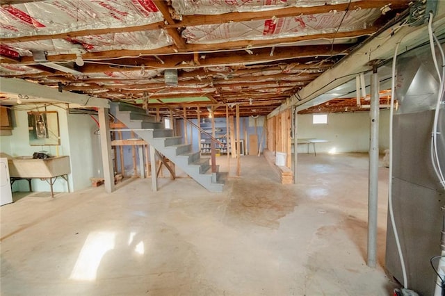 basement featuring heating unit, washer / clothes dryer, and sink