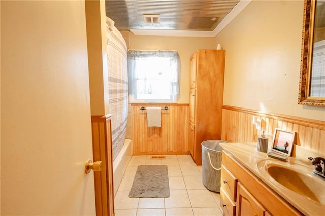 bathroom featuring vanity, tile patterned floors, shower / bathtub combination with curtain, and wood walls