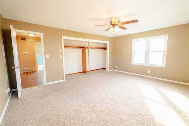 unfurnished bedroom featuring ceiling fan, light carpet, and a closet