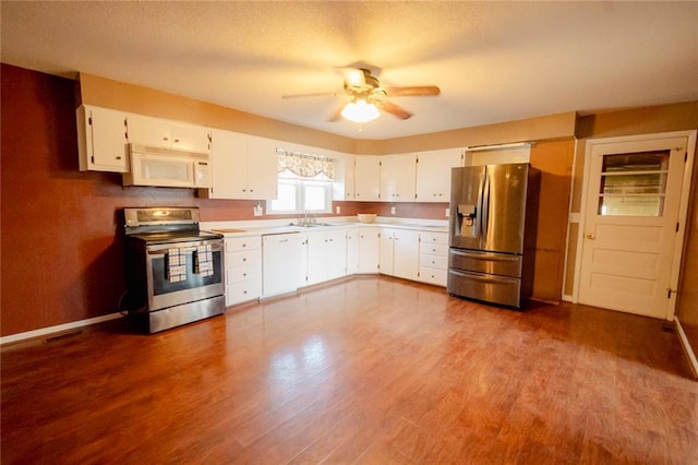 kitchen with ceiling fan, hardwood / wood-style floors, white cabinets, and appliances with stainless steel finishes