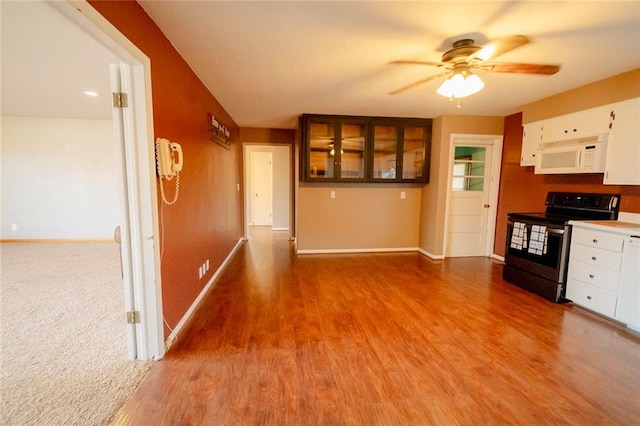 kitchen with wood-type flooring, white cabinetry, and stainless steel range with electric cooktop