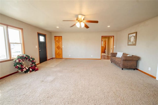 living area with light carpet and ceiling fan