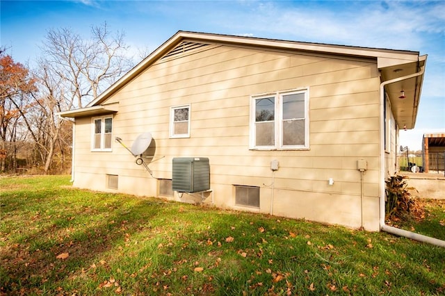 view of property exterior featuring a lawn and central AC