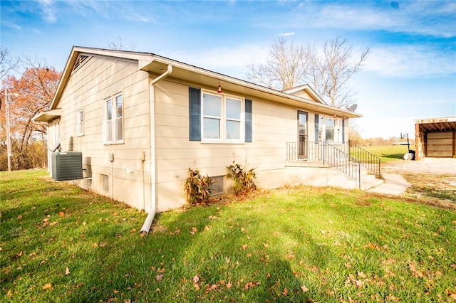 view of side of home featuring central AC and a lawn