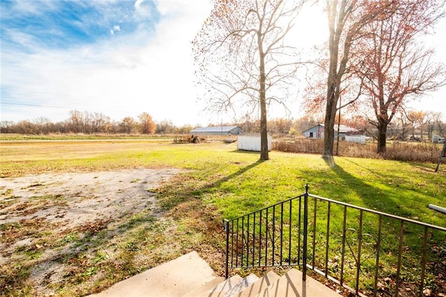 view of yard with a rural view and a storage unit