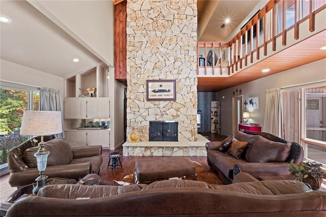 living room with wood-type flooring, a fireplace, and a towering ceiling