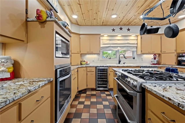 kitchen featuring beverage cooler, stainless steel appliances, sink, dark tile patterned flooring, and wood ceiling