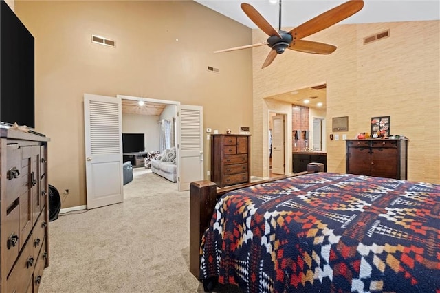 carpeted bedroom with high vaulted ceiling and ceiling fan