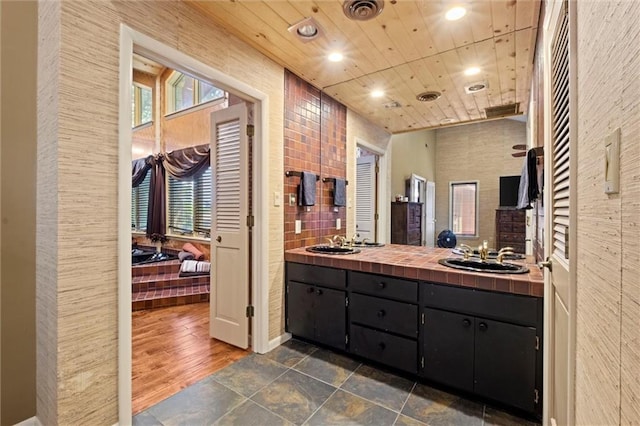 bathroom featuring tile patterned flooring, dual vanity, and wood ceiling