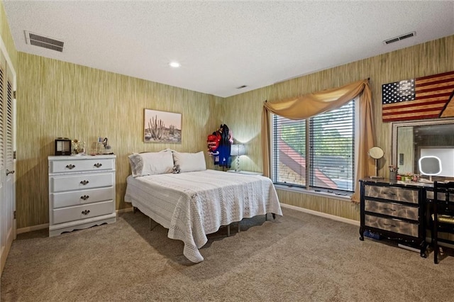 bedroom with wood walls, carpet flooring, and a textured ceiling