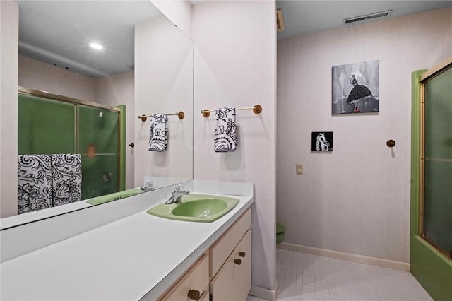 full bathroom with combined bath / shower with glass door, vanity, tile patterned flooring, and toilet