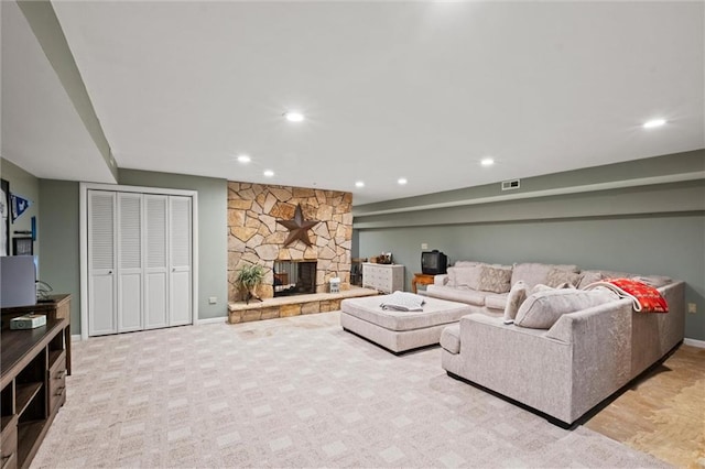 living room with light carpet and a stone fireplace