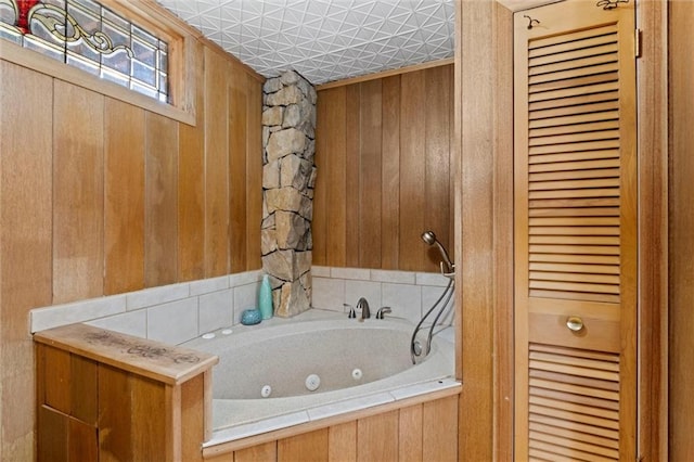 bathroom featuring a washtub and wood walls