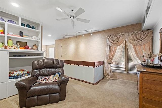 interior space featuring light carpet, track lighting, and ceiling fan