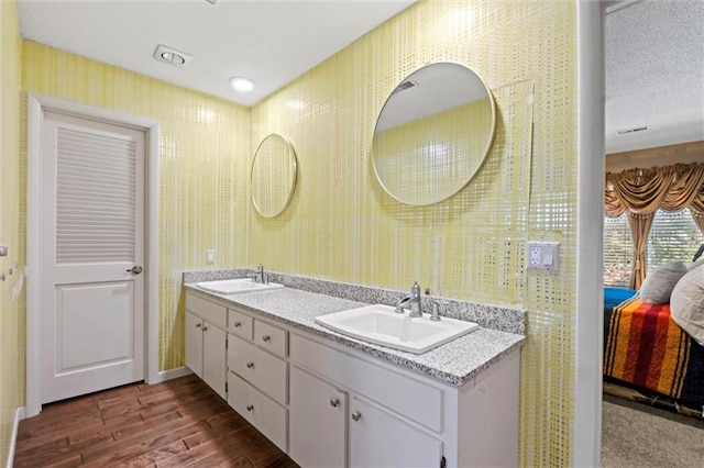 bathroom featuring wood-type flooring and dual bowl vanity