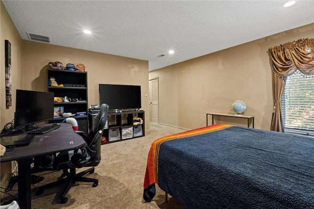 bedroom with light carpet and a textured ceiling