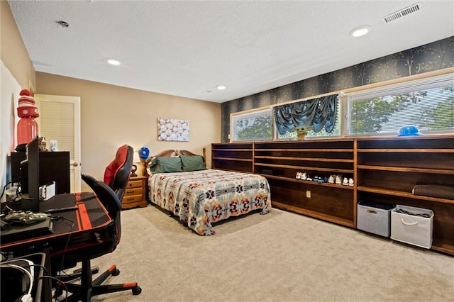 bedroom with light carpet and a textured ceiling