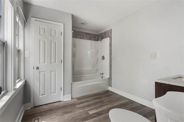 full bathroom featuring a healthy amount of sunlight, bathtub / shower combination, wood-type flooring, and toilet