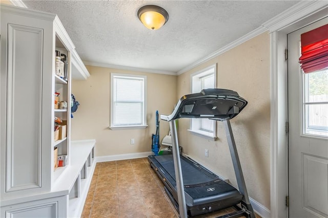 exercise room featuring a textured ceiling, crown molding, and light tile patterned floors