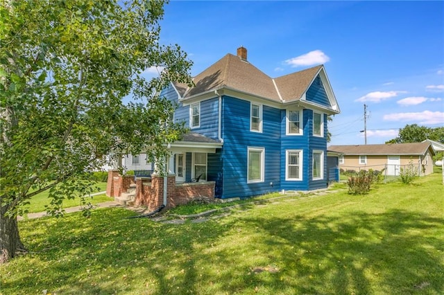 back of property with a porch and a yard