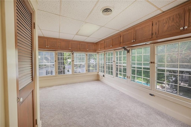 unfurnished sunroom featuring a drop ceiling