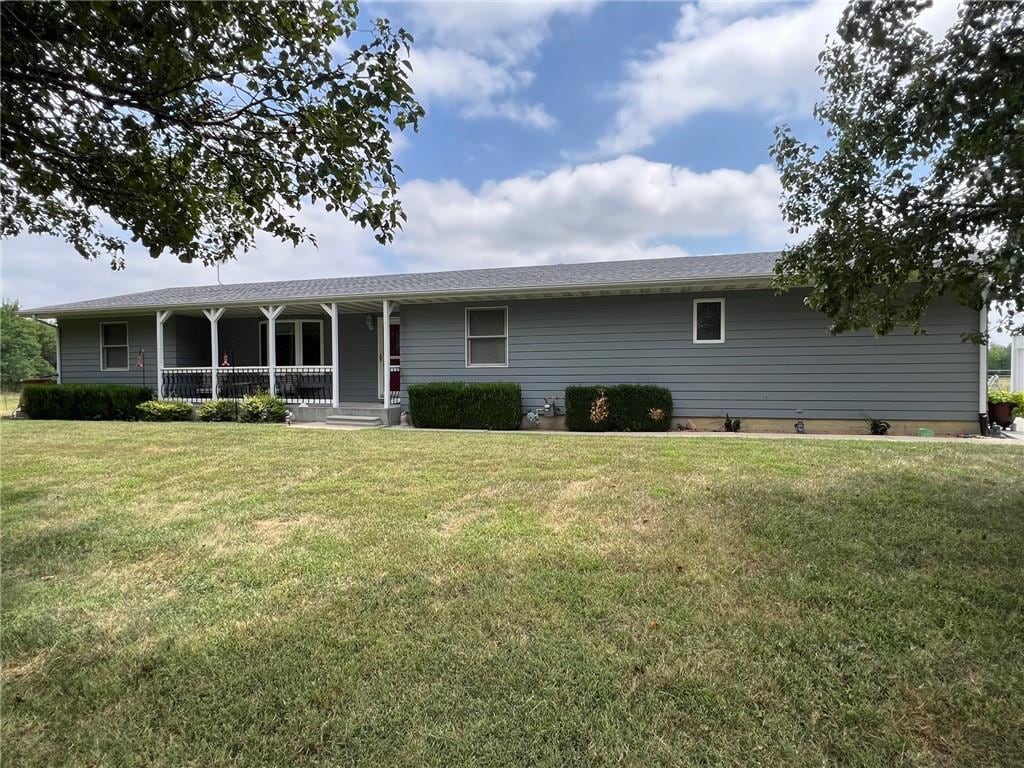 1710 Nevada Rd, Iola, KS 66749 - ranch-style home featuring covered porch and a front lawn