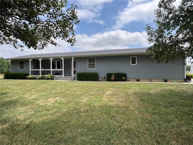 ranch-style home featuring covered porch and a front lawn