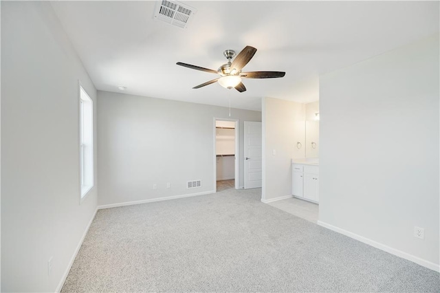 7004 NE 102nd Ct, Kansas City, MO 64156 - unfurnished bedroom with light carpet, a spacious closet, a ceiling fan, ensuite bathroom, and a closet
