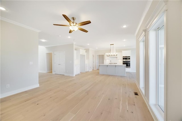 7004 NE 102nd Ct, Kansas City, MO 64156 - unfurnished living room with ornamental molding, ceiling fan, light wood-style floors, and recessed lighting