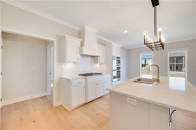 7004 NE 102nd Ct, Kansas City, MO 64156 - kitchen featuring appliances with stainless steel finishes, a center island with sink, tasteful backsplash, light wood finished floors, and light countertops