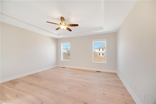 7004 NE 102nd Ct, Kansas City, MO 64156 - empty room with a raised ceiling, light wood-type flooring, and a ceiling fan