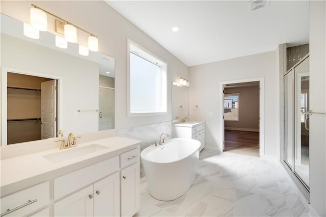 7004 NE 102nd Ct, Kansas City, MO 64156 - bathroom featuring a shower stall, vanity, a freestanding tub, marble finish floors, and a walk in closet
