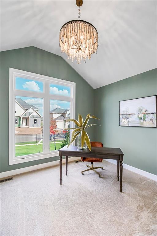 carpeted office space featuring a notable chandelier and vaulted ceiling