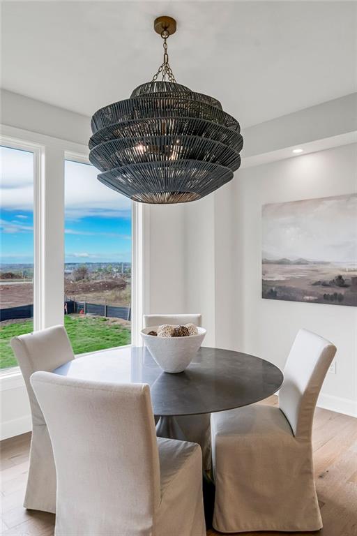 dining area with light wood-type flooring and an inviting chandelier