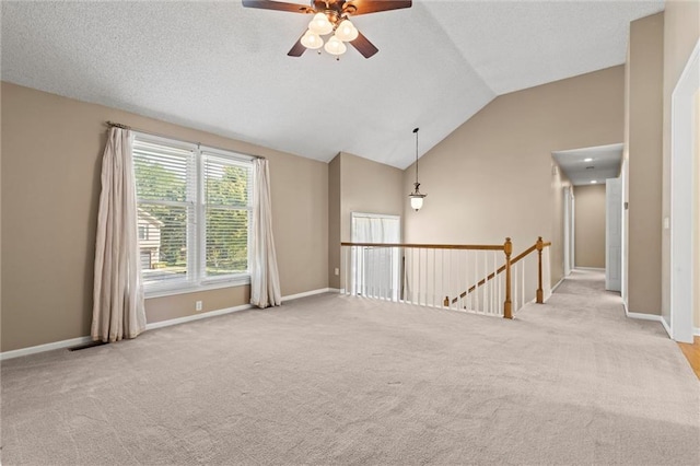 carpeted empty room featuring ceiling fan and vaulted ceiling