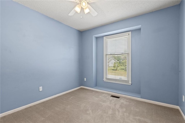 carpeted empty room featuring ceiling fan and a textured ceiling