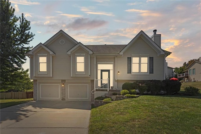 bi-level home with a lawn and a garage