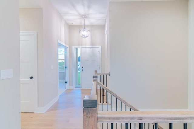 entryway with an inviting chandelier and light wood-type flooring