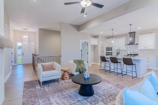 living room featuring light wood-type flooring and ceiling fan