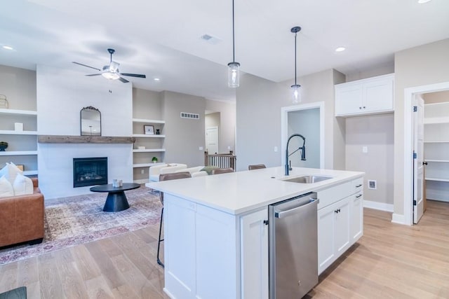 kitchen with sink, decorative light fixtures, a kitchen island with sink, white cabinetry, and dishwasher