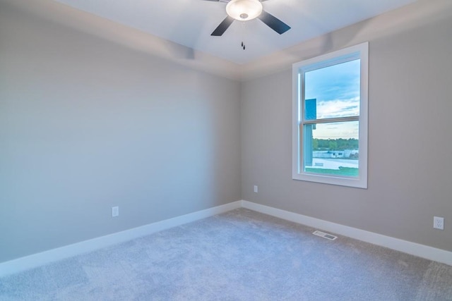 spare room with ceiling fan and carpet