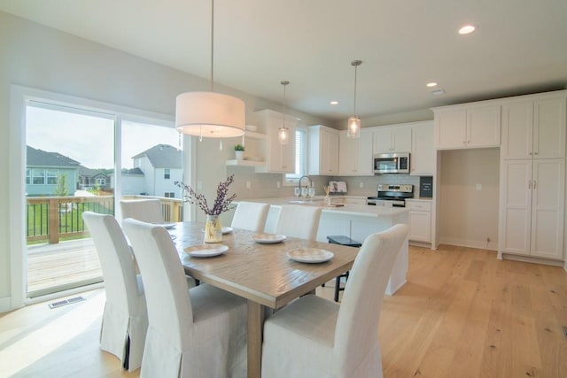 dining space featuring light wood-type flooring and sink