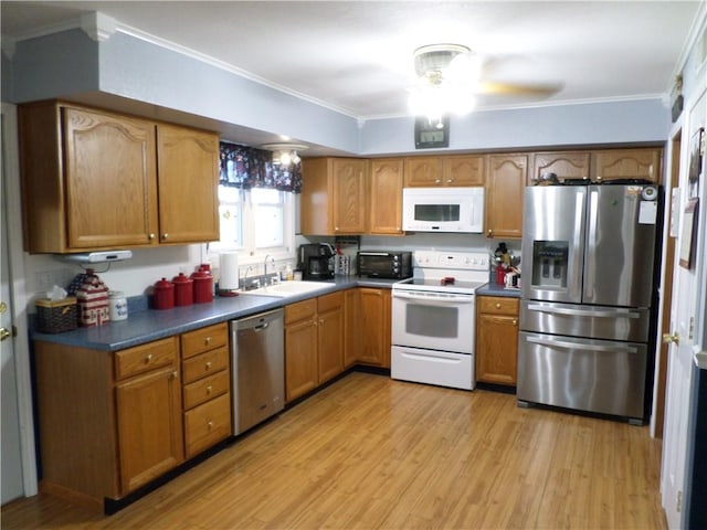 kitchen with light wood-type flooring, crown molding, stainless steel appliances, ceiling fan, and sink