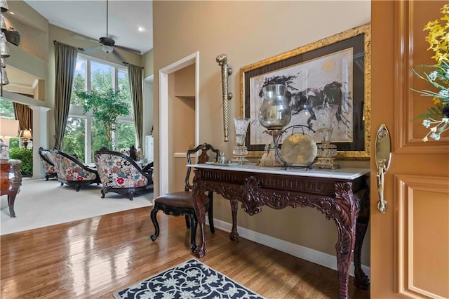 living area with ceiling fan, wood finished floors, and baseboards