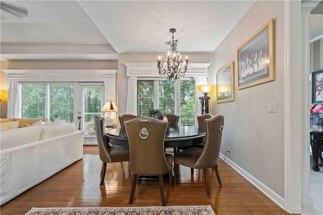 dining room featuring baseboards, a notable chandelier, wood finished floors, and a healthy amount of sunlight