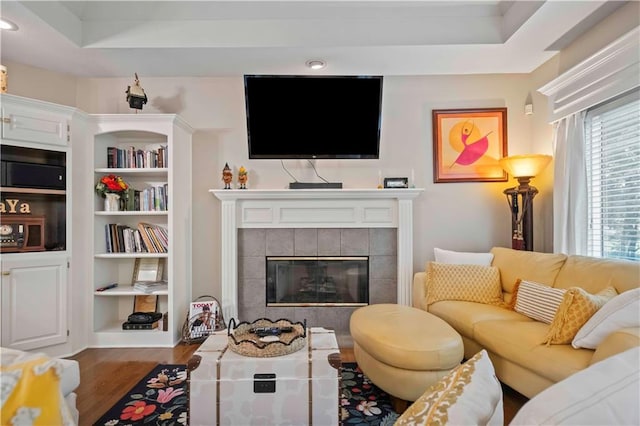 living area with a tiled fireplace and wood finished floors