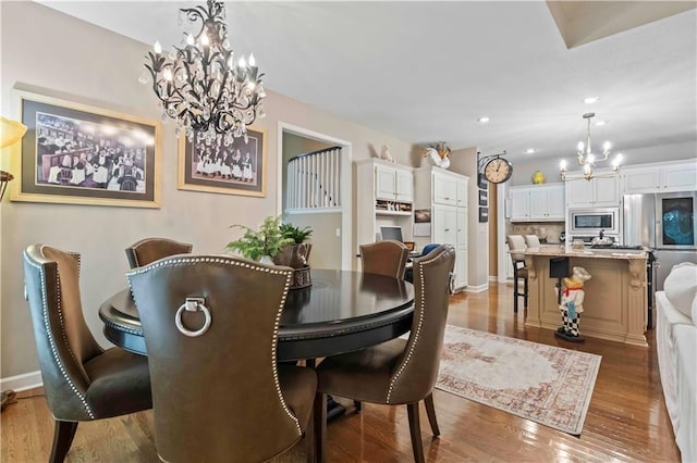 dining area with recessed lighting, a notable chandelier, baseboards, and wood finished floors