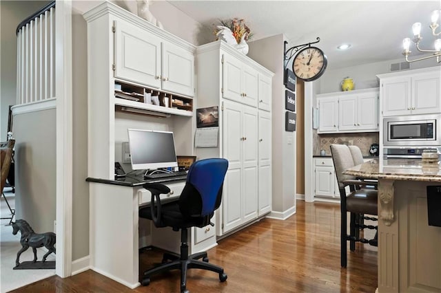 office featuring dark wood-type flooring, a chandelier, visible vents, and baseboards